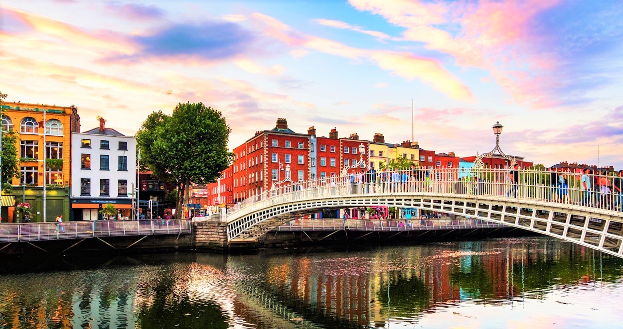 Night view of famous illuminated Ha Penny Bridge in Dublin, Ireland at sunset